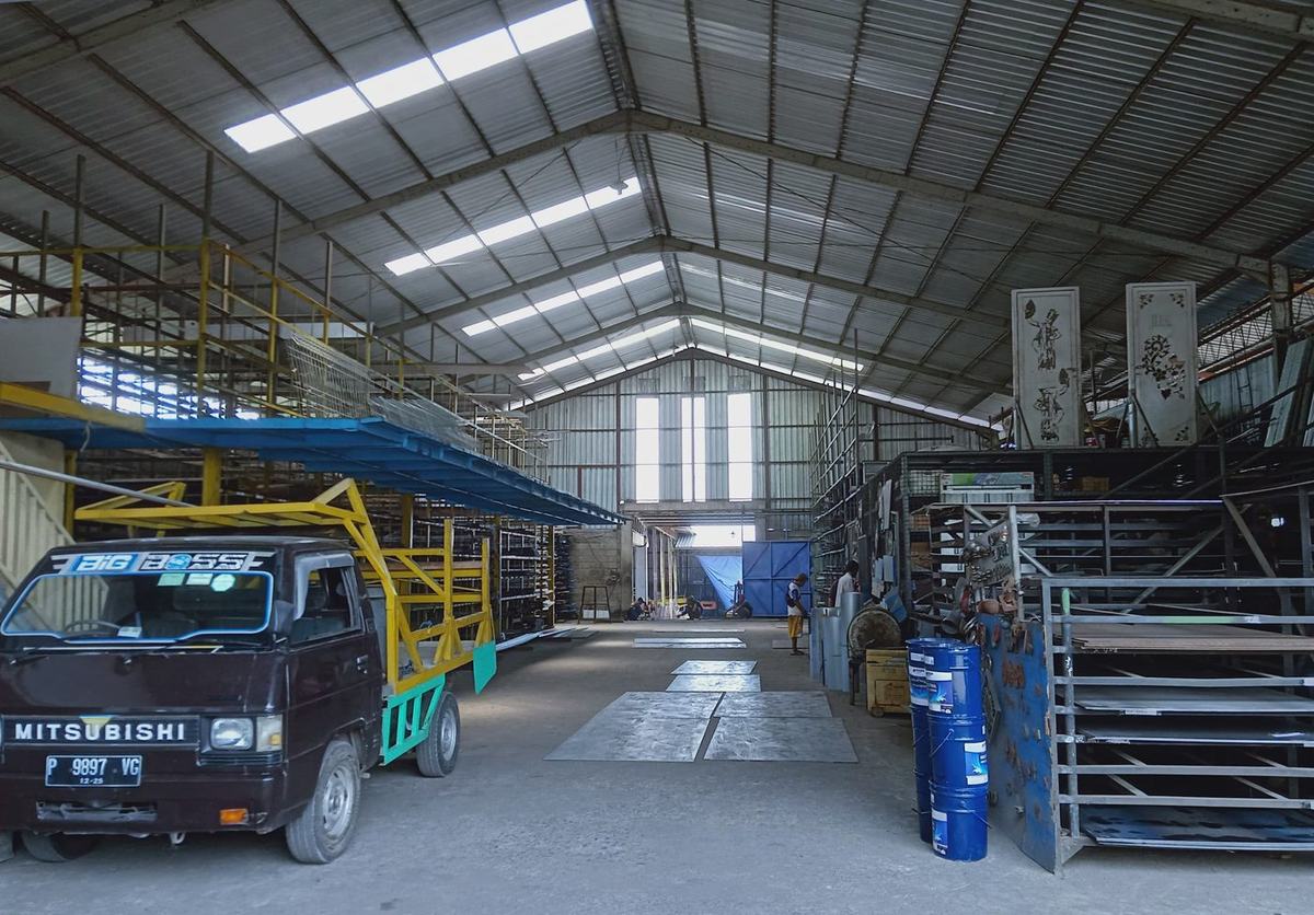 Inside the BCI Banyuwangi factory hall with panel racks and delivery truck